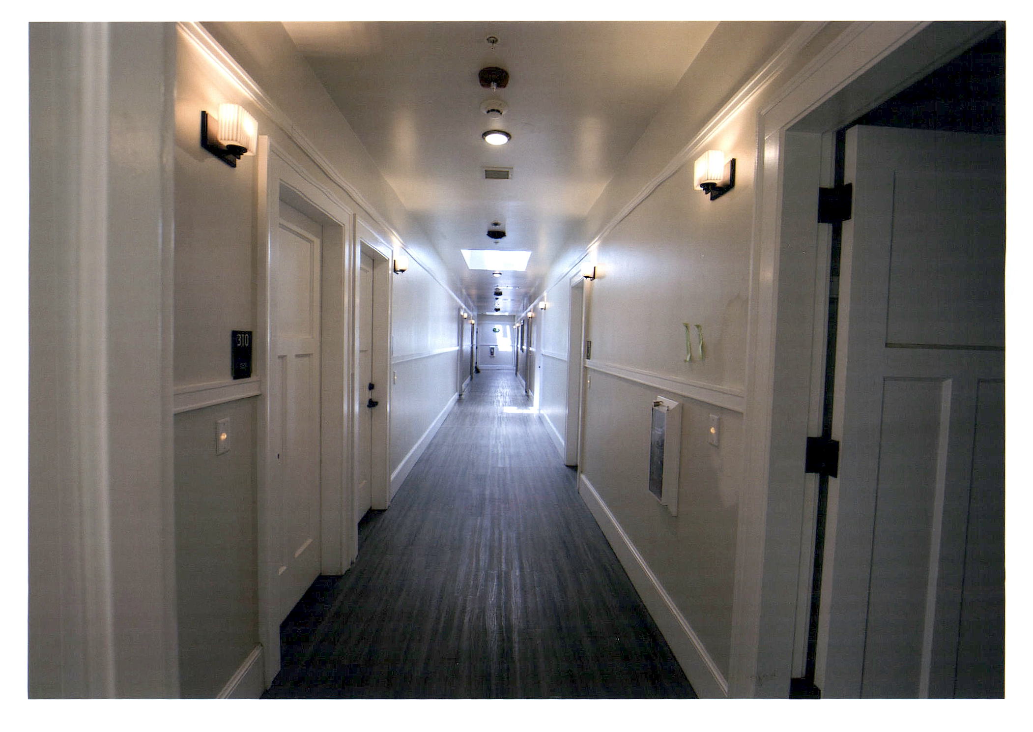 After: view of third floor hallway with skylight in distance.